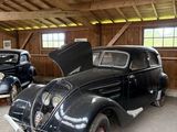 deux vieilles voitures garées dans un garage, le capot ouvert