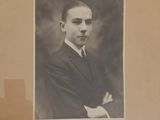 an old photo of a man in a suit and tie posing for a picture
