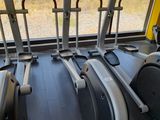 a row of stationary exercise bikes in a gym