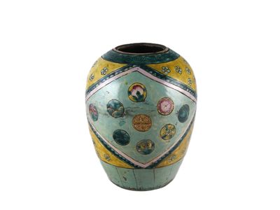 un vase vert orné d'un motif sur fond blanc
