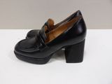 a close up of a pair of black shoes on a white surface