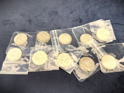 several gold coins are in plastic bags on a blue surface