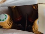 a person opening a bag with three bottles of wine