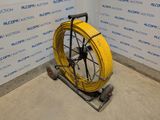 a yellow hose sitting on a cart in a room