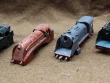 several toy trains are lined up in a row on the ground