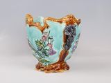 a blue vase with a bird on it on a table