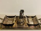 a silver tray with two bowls and a bottle on it