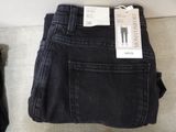 two pairs of black jeans sitting on a couch