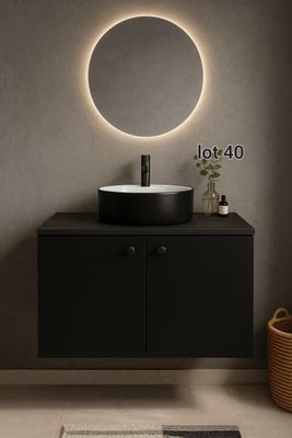 Le meuble de salle de bains est surmonté d'un miroir rond et d'un lavabo noir.
