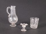trois objets en verre posés sur une table