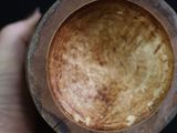 a person holding a brown bowl in their hand