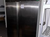 stainless steel double door refrigerator in a commercial kitchen with shelves
