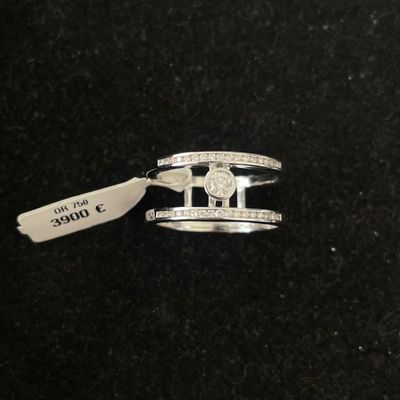 a close up of a ring on a black surface with a tag