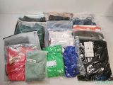 beaucoup de vêtements qui sont dans des sacs posés par terre