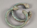 paire de bracelets en bronze ornés de lézards sur un fond blanc