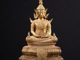 a gold statue of a person sitting on top of a table