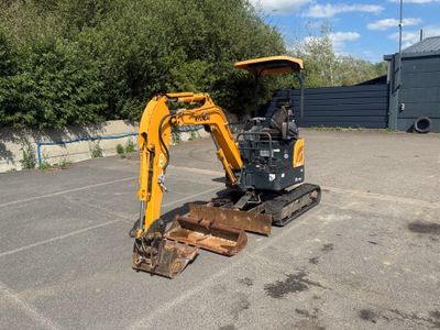 une petite excavatrice garée sur un parking