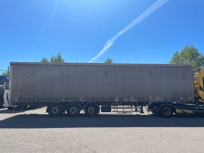 the semi truck is parked in the parking lot next to the building