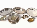 several silver dishes and spoons on a white surface