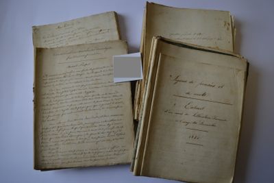 several old papers are stacked on top of each other on a table