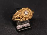gros plan d'une bague en or et diamants sur une surface noire