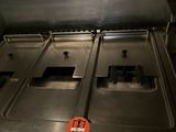 stainless steel counter top with three deep fryers in a commercial kitchen