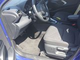 the interior of a blue car with the door open and the steering wheel down