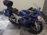 une moto bleue garée sur un sol à damier