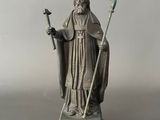 an image of a statue of a priest holding a staff