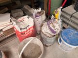 many buckets of cement sitting on the floor next to each other