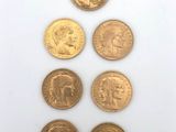 a group of five different coins on a white surface