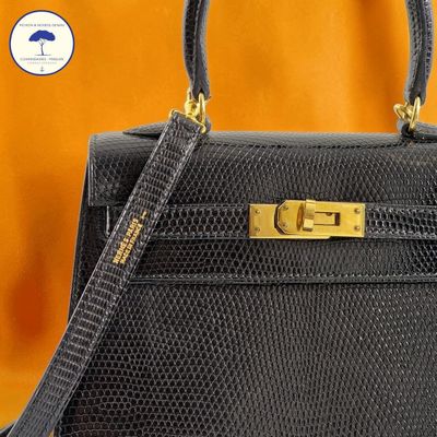 an image of a black handbag with a gold handle