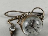 a small clock that is attached to a chain