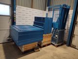une palette bleue posée dans un entrepôt, contre un mur