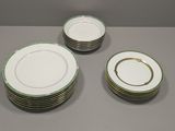 quatre assiettes à bord doré et bordure verte sur fond gris