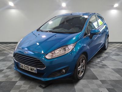 une ford fiesta bleue garée sur un sol en damier dans un garage
