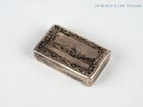 an old silver box sitting on top of a white surface