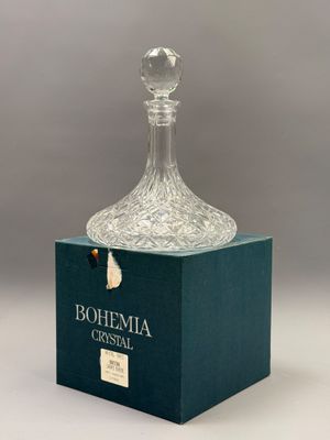 a clear glass decante bottle sitting on top of a green box