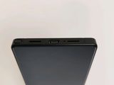the back of a black cell phone sitting on top of a white table