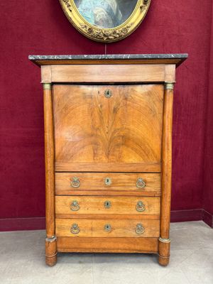 an antique wooden chest of drawers with marble top in a room with red walls