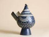 une théière bleue et blanche contenant une cuillère