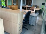 a man that is standing next to a desk in an office