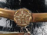 a close up of a helmet with a gold flower on it