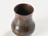 a small brown vase sitting on a white surface