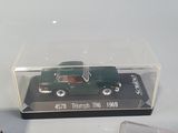 a green toy car in a clear box next to a red toy car