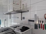 a kitchen with a sink and a bunch of knives hanging on the wall
