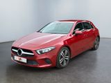 une Mercedes CLA rouge garée dans une pièce blanche