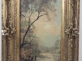 un tableau représentant un paysage fluvial, encadré d'or, accroché au mur
