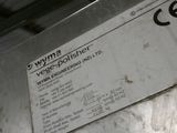 une pancarte apposée sur le côté d'une machine sur laquelle est inscrit « Wyma »