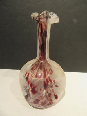 a glass vase with blood on it sitting on a table